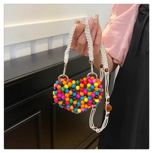 Close-up of heart-shaped beaded bag featuring colorful beads and woven cotton strap