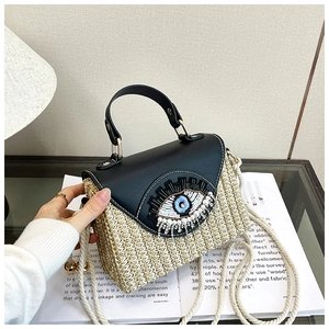 Détail du sac en paille tissée avec rabat en cuir et broderie de perles en forme d'œil