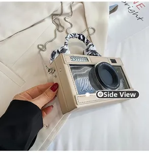 Close-up of camera-shaped bag with scarf-wrapped handle and metal chain strap