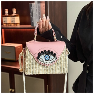 Détail du rabat en cuir rose et corps en paille avec œil perlé et bandoulière en corde