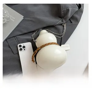 Dettaglio borsa a tracolla bianco crema a forma di zucca con catena argento e decorazione