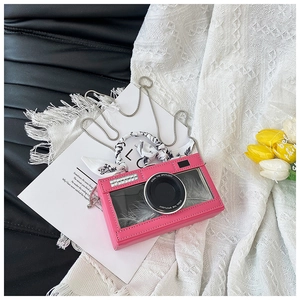 Detail of pink camera-shaped bag with grey feather interior and silk scarf handle decor