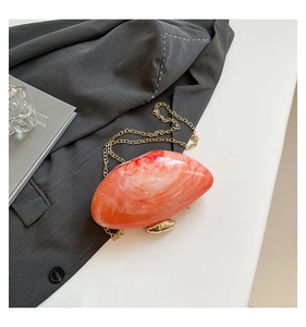 Detail of marble pattern acrylic handbag with gold chain strap and metallic clasp