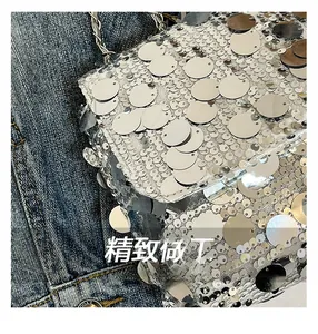 Détail macro des paillettes argentées et de la chaîne sur un sac carré élégant