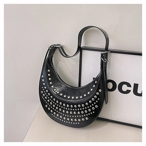 Détail du sac hobo noir avec des rivets punk argentés et une bandoulière réglable