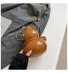 Dettaglio borsa a tracolla marrone a forma di zucca in pelle PU con catena in metallo