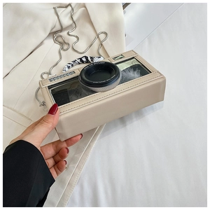 Detail of camera-shaped crossbody bag with silk scarf handle and silver chain strap