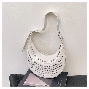 Détail du sac demi-lune blanc avec rivets argentés et bandoulière réglable