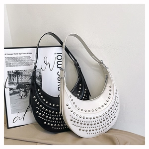 Gros plan de sacs hobo croissants noir et beige avec rivets punk argentés et cuir lisse