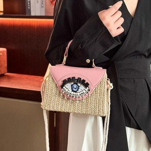 Sac bandoulière en paille et cuir rose avec œil perlé artisanal et détail de franges