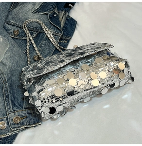Gros plan du sac bandoulière à paillettes argentées avec chaîne et texture métallique