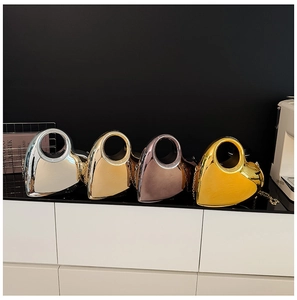Metallic heart-shaped evening bags in silver, gold and rose gold with round handles