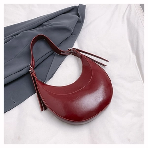 Détail du sac hobo bordeaux en cuir brillant avec boucle en métal argenté sur tissu