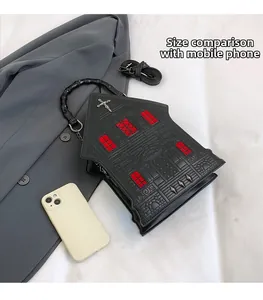 Gothic house-shaped handbag with red windows and black bamboo handle shown next to iPhone