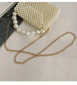 Close-up of a cream woven pearl mini bag with large pearl handle and gold chain strap