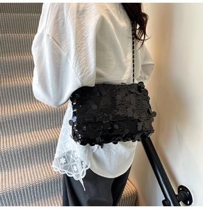 Détail du sac à bandoulière en paillettes noires avec fine chaîne en métal pour femme