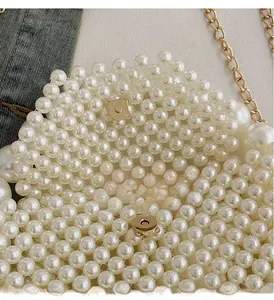 Detail of beaded pearl handbag showing gold magnetic buckle closure and woven craftsmanship