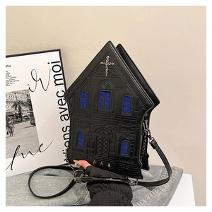 Detailed shot of gothic cathedral-shaped bag with stone texture and metal cross charm