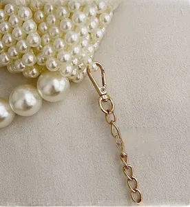 Close-up of pearl woven bag featuring premium gold metal hooks and luxury chain detail