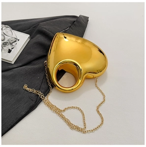 Macro detail of glossy gold heart-shaped acrylic bag with sleek metallic finish