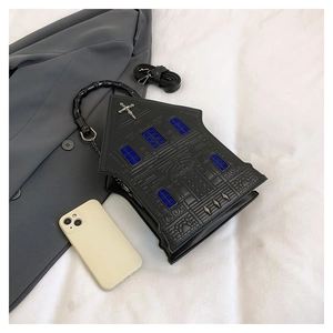 Detail of gothic house-shaped handbag with rivet cross and bamboo handle on white fabric
