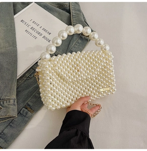 Close-up of hand-woven faux pearl handbag with gold logo plate and chain strap detail