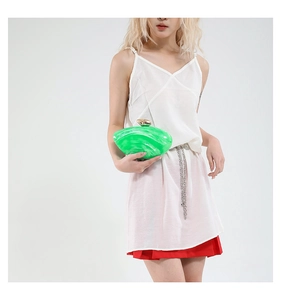 Detail of emerald green marble texture acrylic evening bag with gold metal clasp