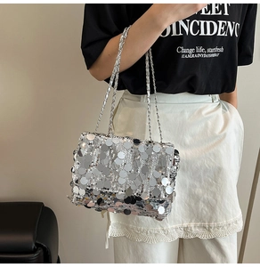 Détail du sac bandoulière à paillettes argentées avec chaîne en métal et texture brillante