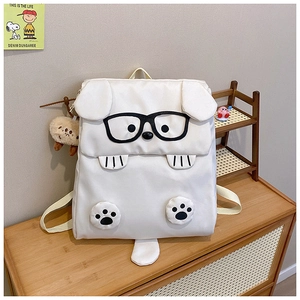 Detail shot of a cute white cartoon dog backpack with black glasses and plush ears