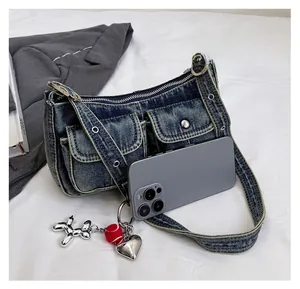 Detailed view of blue denim Y2K shoulder bag with silver studs and balloon dog charm