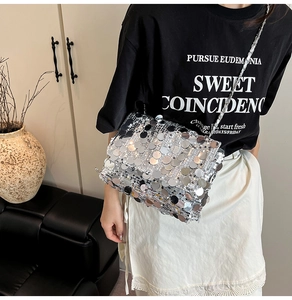 Détail du sac à bandoulière à paillettes argentées avec chaîne en métal tressé sur modèle