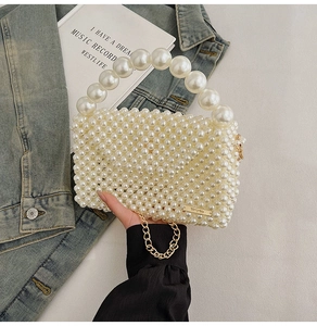 Detail of handmade pearl woven bag with large beaded handle and gold metal chain strap