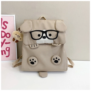 Detailed view of the cute cartoon dog backpack in beige with plush pendant and ears