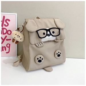 Close-up of khaki dog cartoon backpack featuring 3D glasses, floppy ears and plush charm