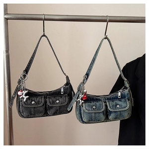 Detail of vintage washed denim shoulder bags with utility pockets and dog charms