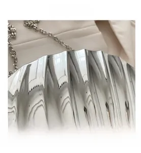 Macro shot of silver metallic shell bag showing high-shine texture and chain strap
