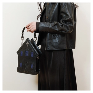 Detail of gothic church style handbag with silver cross pendant and bamboo handle