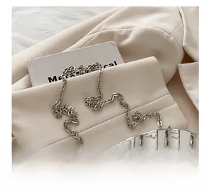 Close-up of a silver metal chain strap on a quilted shell-shaped box bag