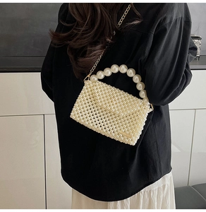 Detailed view of pearl beaded handbag featuring large pearl handle and golden chain strap