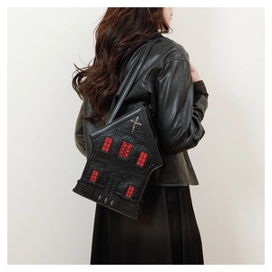 Female model wearing a gothic church-shaped shoulder bag with red window details and cross
