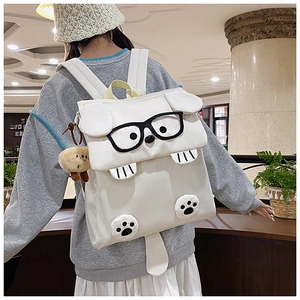 Detail view of the cute 3D cartoon dog backpack with tail and plush charm on a model