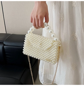 Detailed shot of a woven pearl bag with elegant gold chain and large bead handle strap