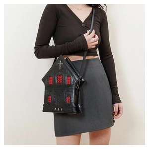 Close-up of gothic house-shaped crossbody bag with red windows and silver cross detail