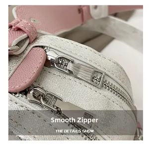 Detail of smooth silver dual zippers and textured pearl white leather on the cute rabbit bag