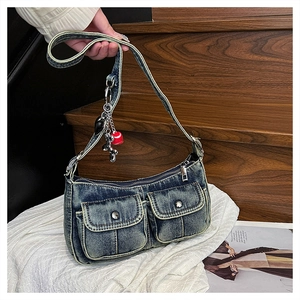 Detailed close-up of retro washed denim shoulder bag with silver rivets and zippers