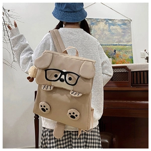 Rear view of beige cartoon dog backpack with 3D ears and tail in a cozy home setting