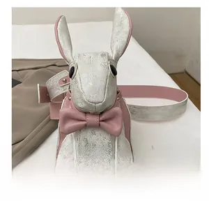 Close-up of metallic silver rabbit crossbody bag with pink bow and ribbon detail
