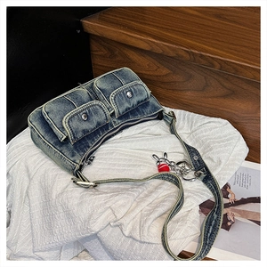 Detail of vintage denim shoulder bag with double pockets and cute bunny accessory