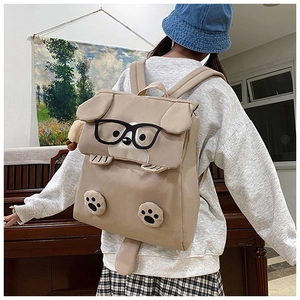 Detail of cute khaki dog backpack showing hanging ears and glasses in cozy room