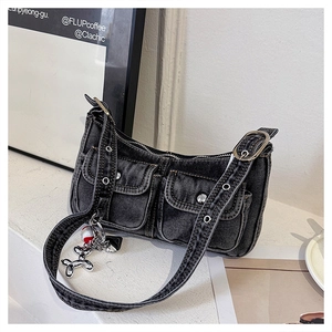 Detail of washed black denim shoulder bag featuring utility pockets and silver metal hardware